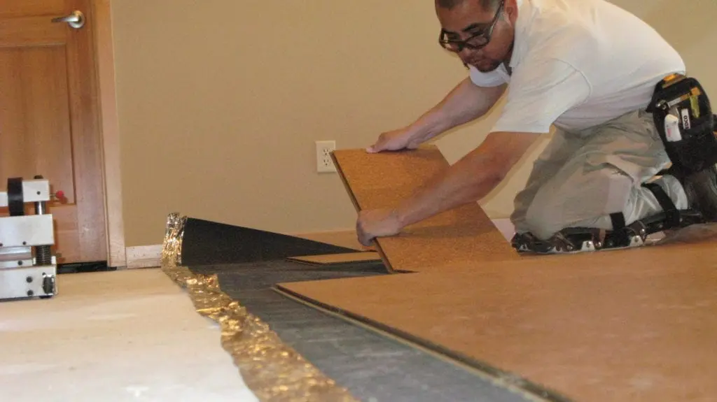 Alberto Aguilar, laying cork flooring.